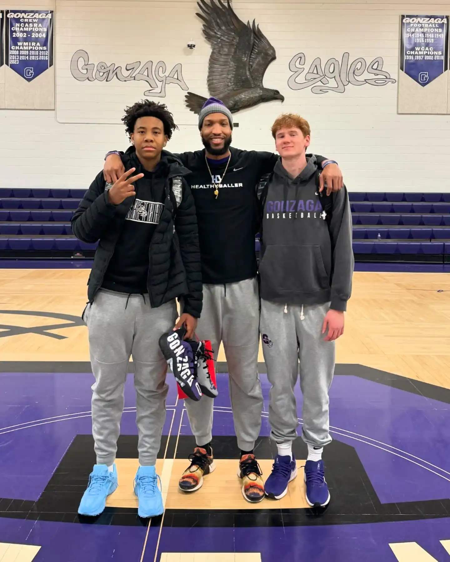 Three basketball players on court at Gonzaga Eagles.
