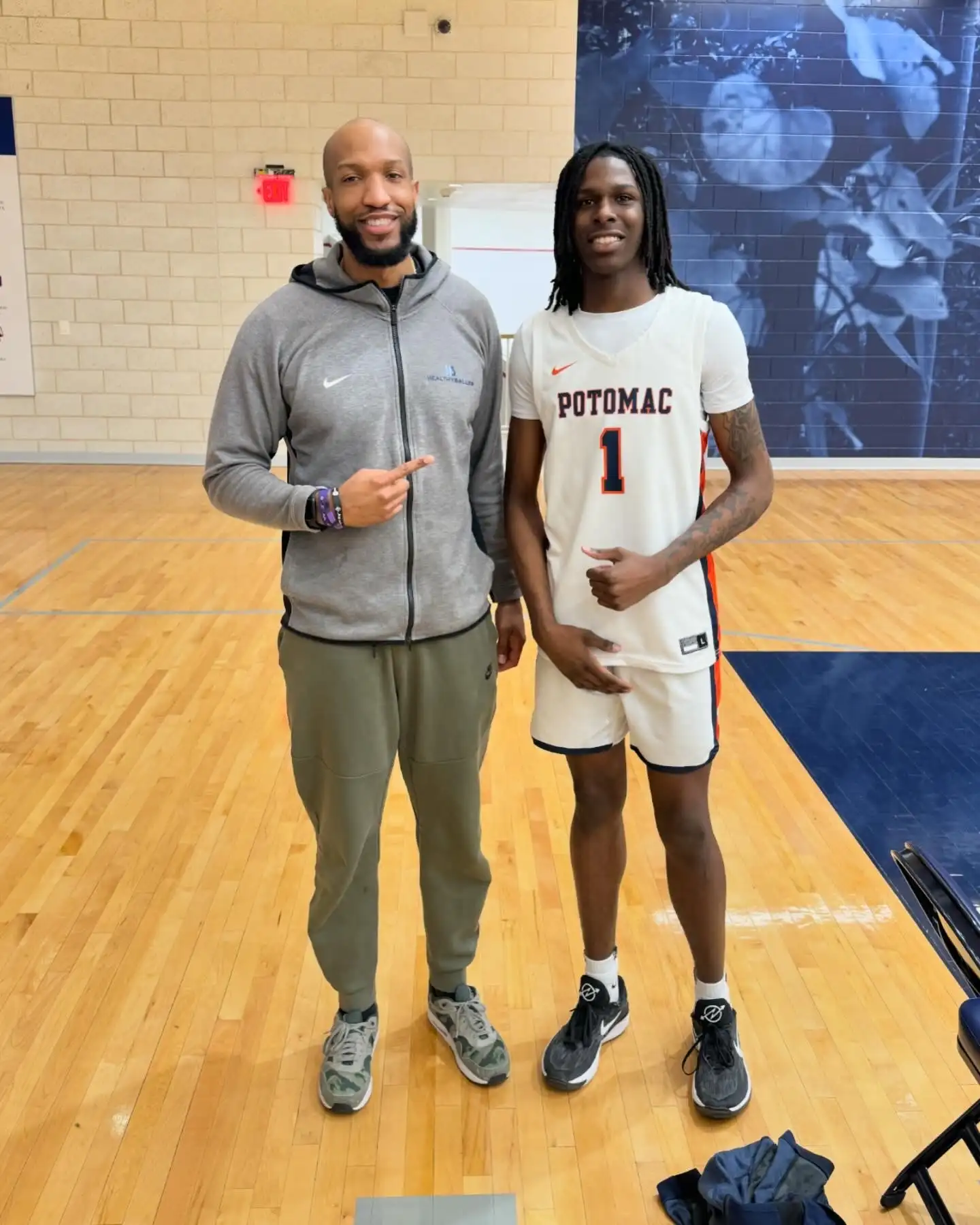 Two men in gym, one in basketball uniform.