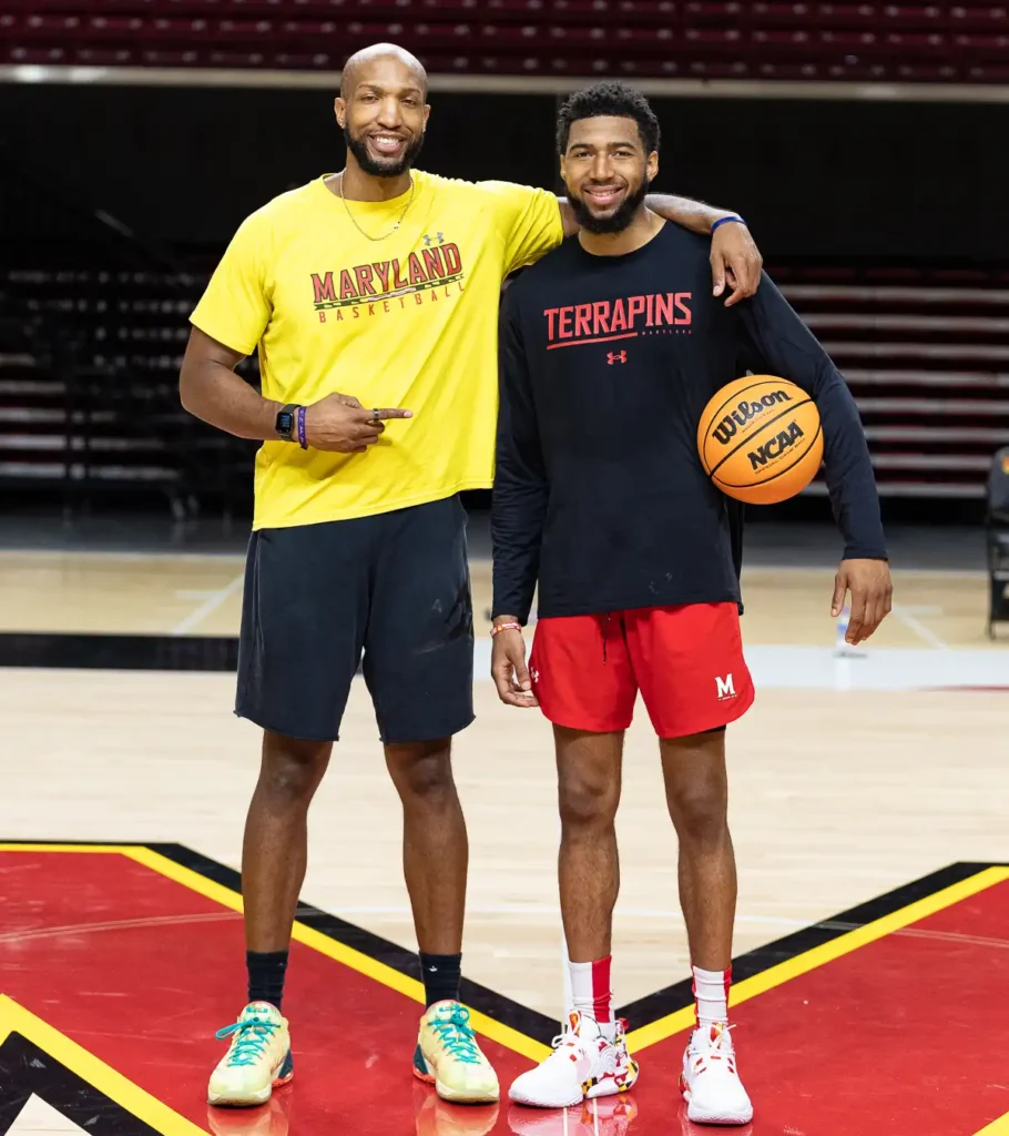 Two basketball players on court with ball.