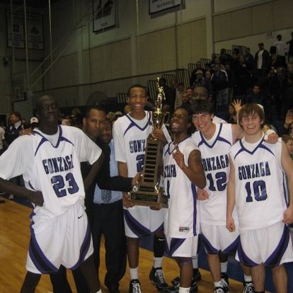 Basketball team celebrating with championship trophy