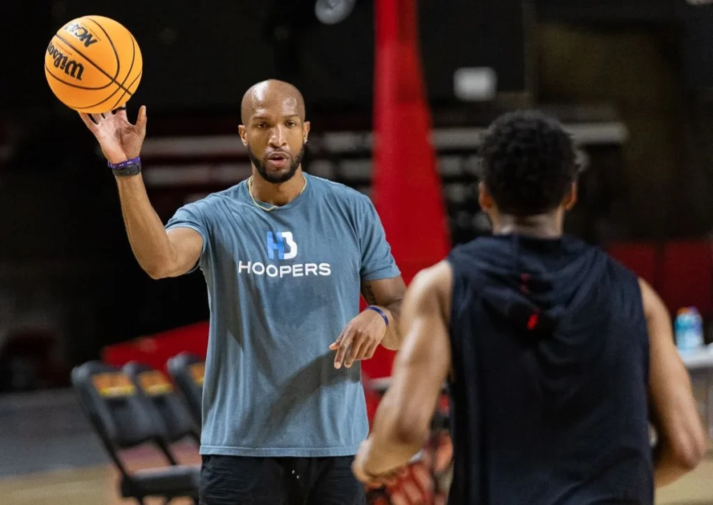 Basketball coach instructs player with a ball