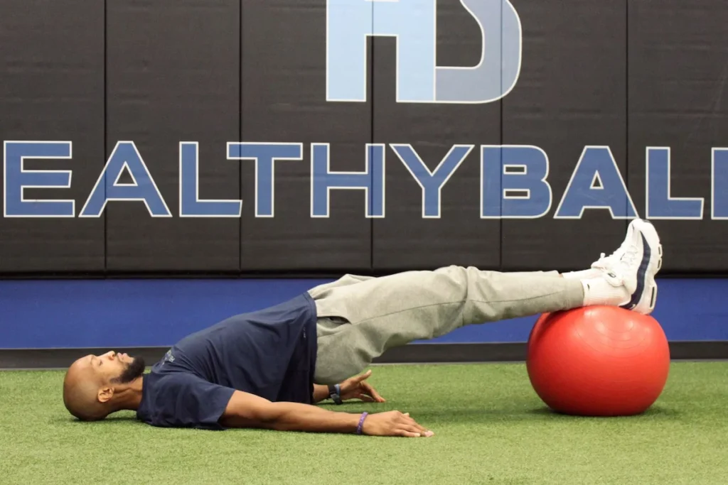 Man performing exercise with stability ball on floor