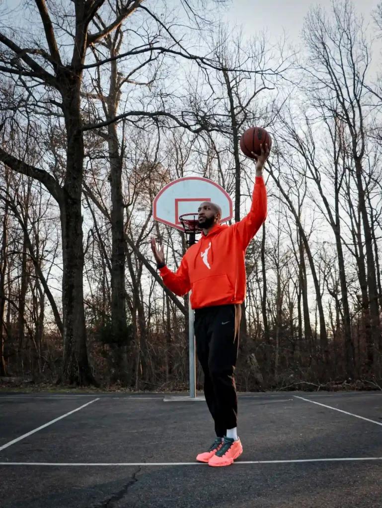 Person playing basketball on outdoor court.
