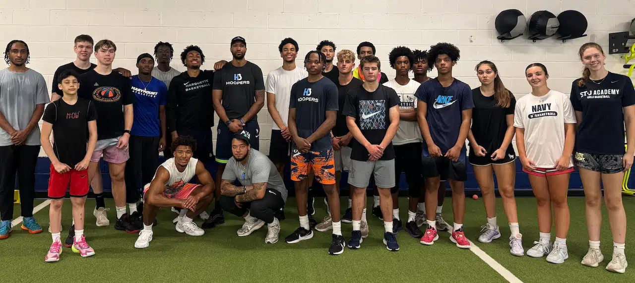 Group of basketball players indoors posing together.
