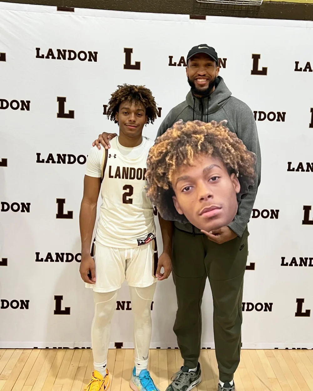 Basketball player posing with giant face cutout.