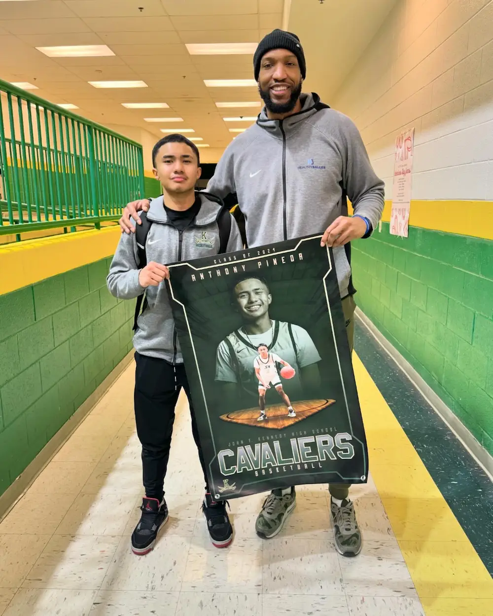 Two people holding Cavaliers basketball poster.