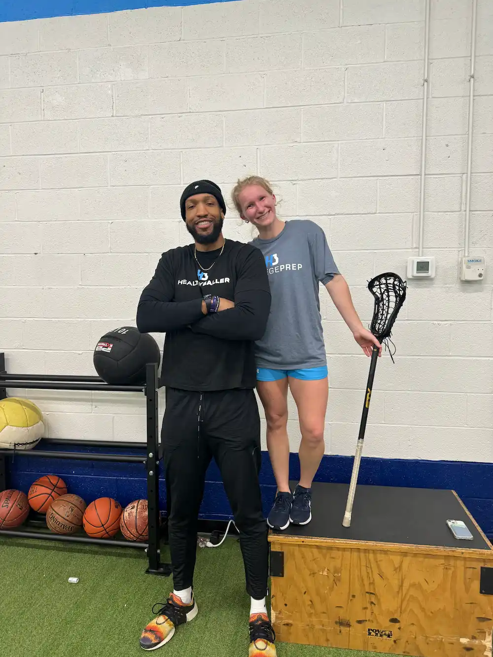 Athletes posing with sports equipment in gym