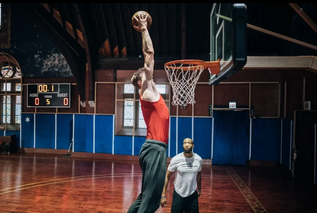 Basketball player dunking in indoor court